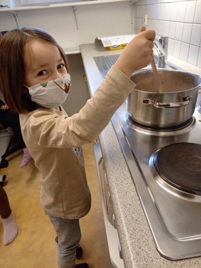 Kind rührt in großem Kochtopf